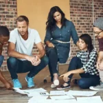 A diverse team of business professionals working together on a project, collaboratively planning a strategic business exit.