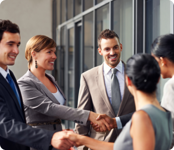 A group of business professionals shaking hands, symbolizing a new partnership and a successful business deal.